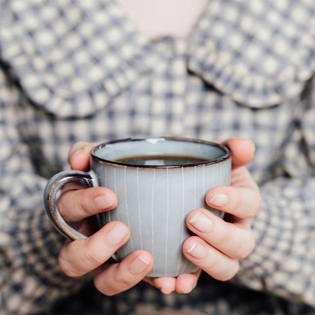 kvinde holder om kaffe lavet på kaffemaskine til formalet kaffe